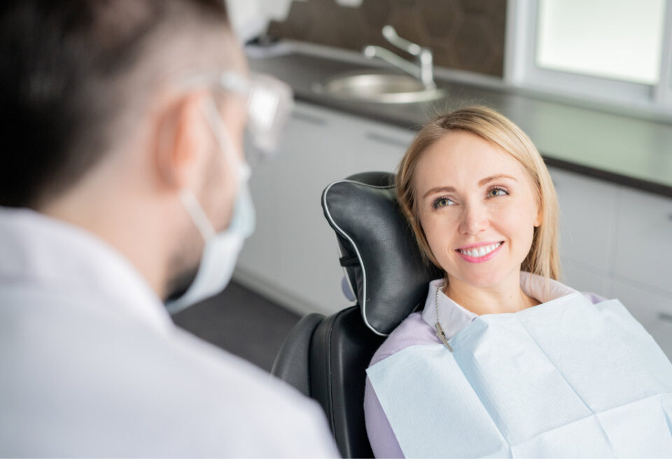 Blonde woman smiles at her dentist in Bellevue, WA, during her comprehensive dental checkup