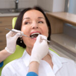 Brunette woman smiles while receiving a dental checkup at her dentist in Bellevue, WA
