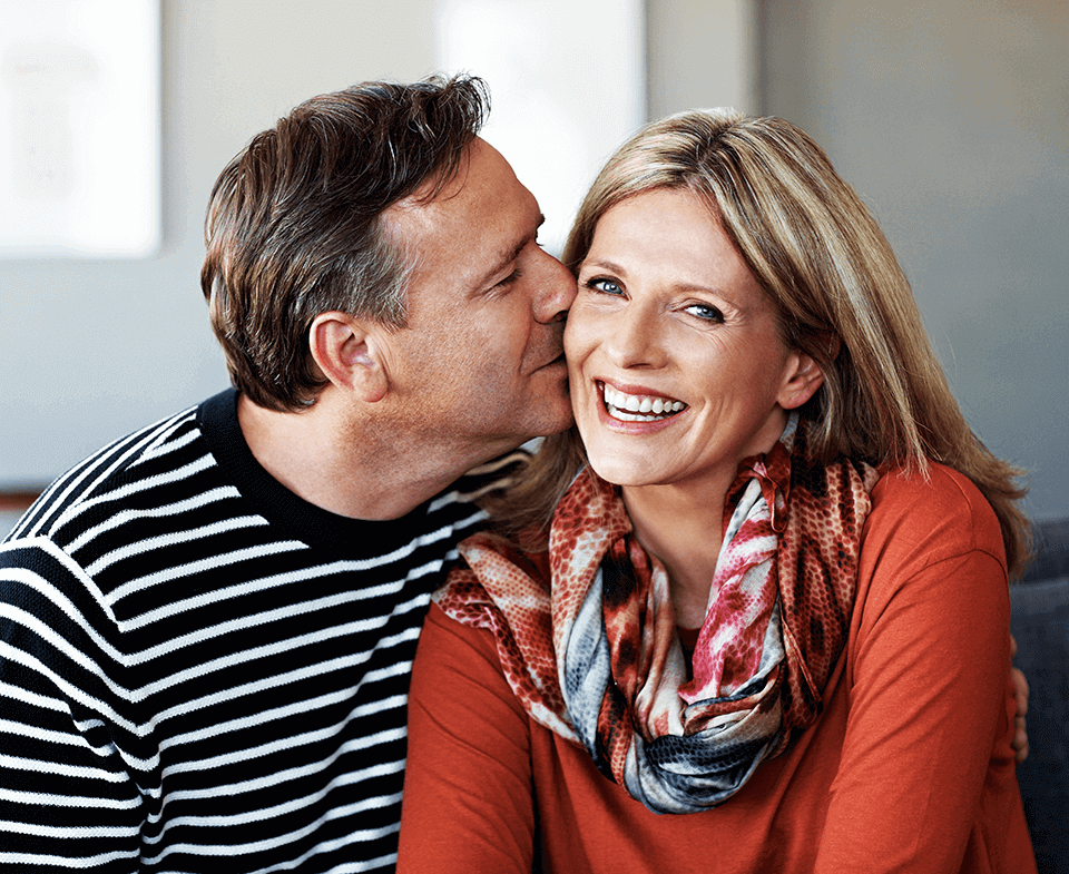 man kissing woman on the cheek