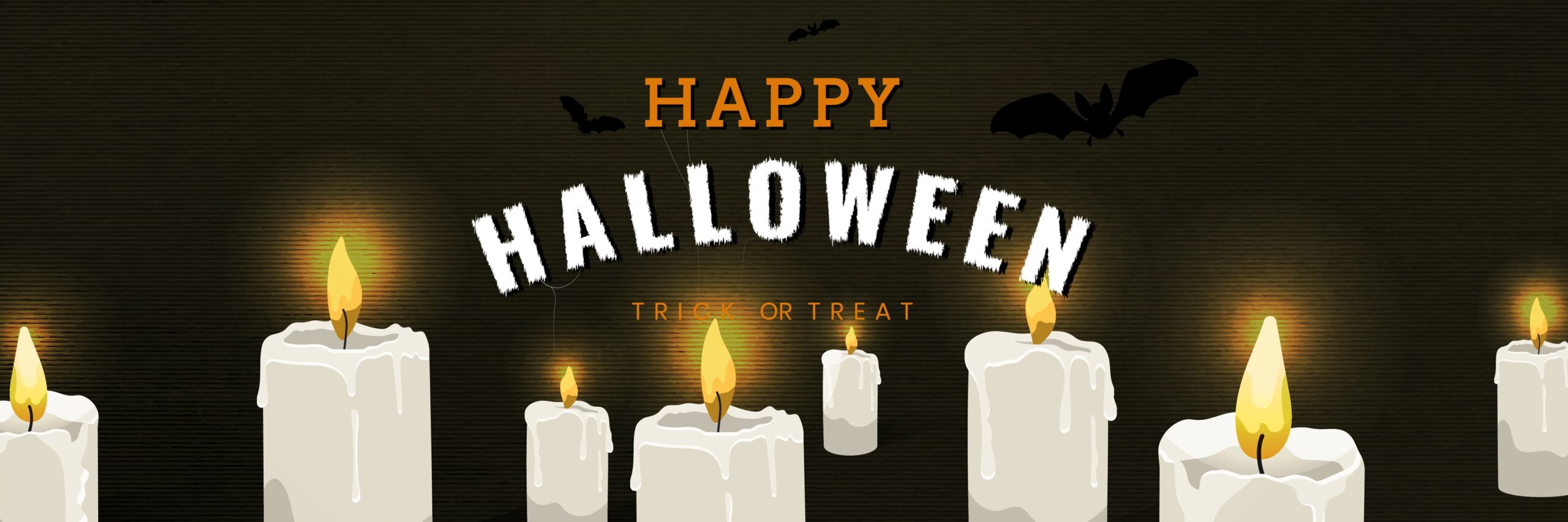 HAPPY HALLOWEEN TRICK OR TREAT on a black background above lit candles to celebrate the season of candy