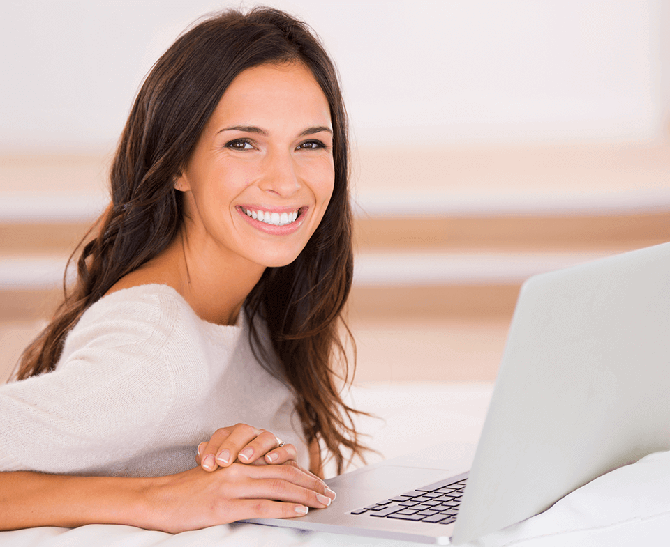 woman smiling next to a computer