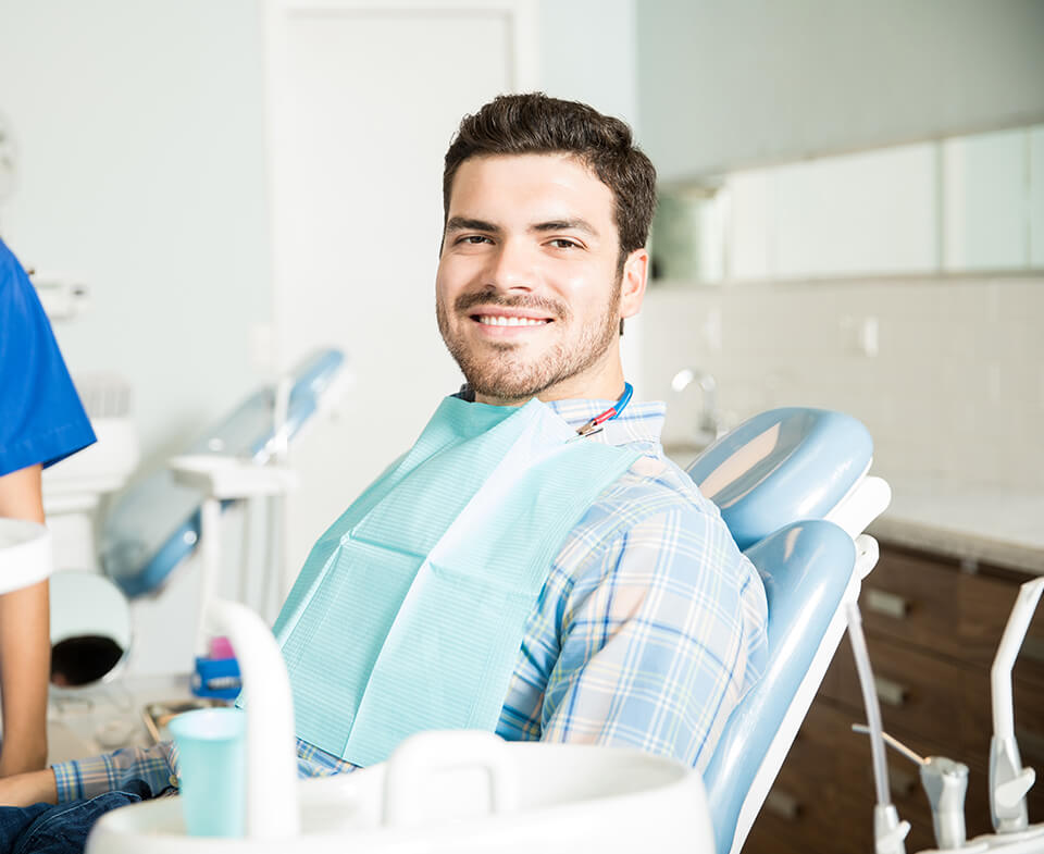 smiling man sitting in a dental chair