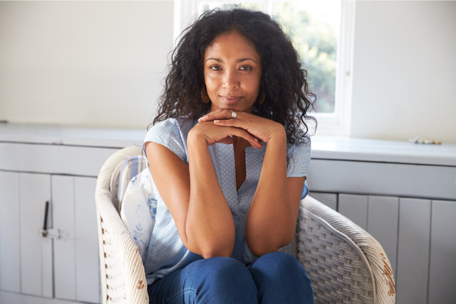 Curly-haired woman smiles after BOTOX has reduced the wrinkles and fine lines around her smile in Bellevue