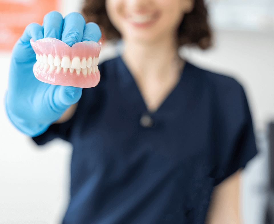 woman holding dentures