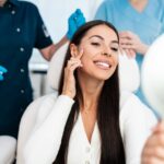 woman admiring her face in mirror after Botox